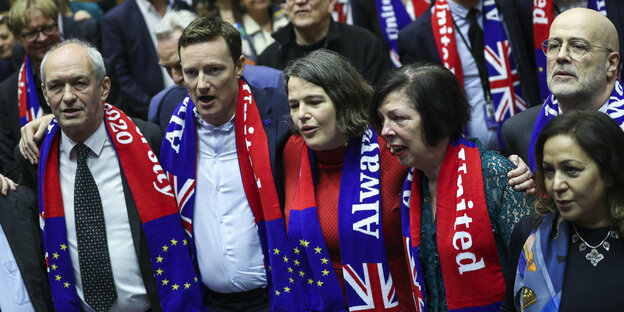 Parlamentarierinnen und Parlamentarier singen, sie tragen Schals mit der Europafahne und dem Union Jack