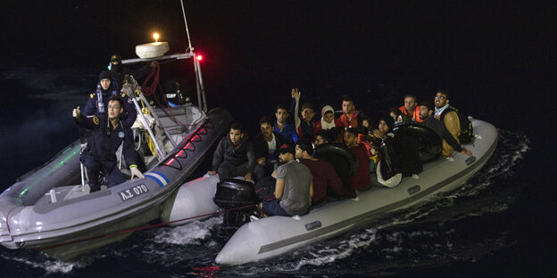 Ein Helfer der griechischen Küstenwache gestikuliert an Bord eines Bootes während einer Rettungsaktion.