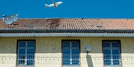Abschiebungsgefängnis Langenhagen: Ein gelber Bau mit Gittern vor den Fenstern, im Hintergrund ein Flugzeug