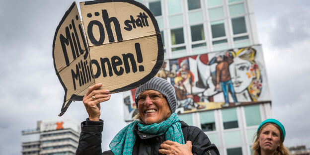 Demonstratin hält ein Schild hoch auf dem "Miljöh statt Millionen steht.