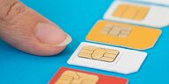 Ein Finger zeigt auf mehrere Prepaid Telefonkarten.