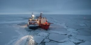 Zwei Schiffe dicht nebeneinander in einer Eislandschaft
