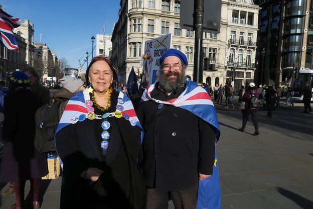 Pauline Adams und Simon Wilkes sind eingehüllt in Union-Jack und EU-Flagge