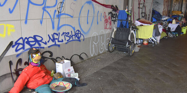 Unter einer Bahnbrücke in Berlin, Ostbahnhof, stehen Habseligkeiten von Obdachlosen