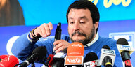 Matteo Salvini zieht Grimasse vor Mikrofonen mit italiensicher Schrift