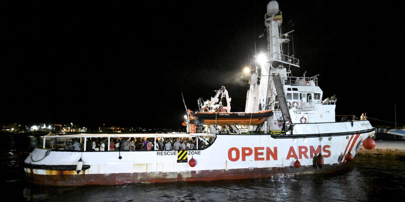 Ein Schiff liegt nachts in einem Hafen