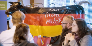 Modell einer Kuh im Maßstab 1:1, das mit als Deutschlandfahne bemalt ist und der Aufschrift "Die faire Milch" trägt