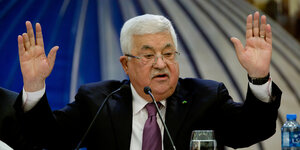 Abbas spricht in ein Mikrofon und hebt beide Arme