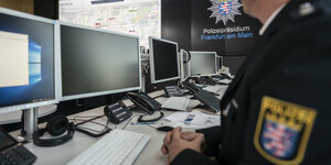 in Polizist sitzt bei einem Pressetermin in der neuen Befehlsstelle im Polizeipräsidium an den Monitoren.