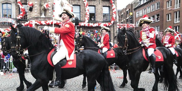 Karnevalsumzug am Rosenmontag 2017, Jecken in roten Uniformen auf Pferderücken