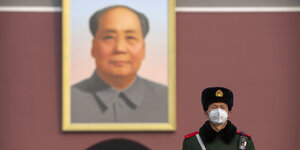 Mao-Bild und Wachmann mit Mundschutz