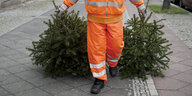 Ein Mitarbeiter der Berliner Stadtreinigung entsorgt Weihnachtsbäume