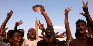 Männer und Jungen jugeln und machen das Victory Zeichen