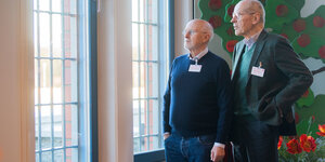 Dirk Roßmann und Christian Pfeiffer stehen vor einem vergitterten Fenster in der JVA Sehnde