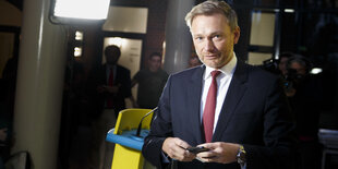 Christian Lindner, ein Mann in Anzug geht am Rednerpult vorbei