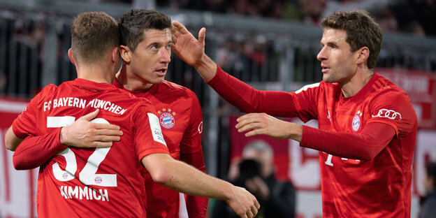 Drei Spieler des FC Bayern liegen sich in den Armen