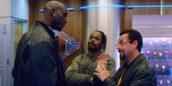 Howard Ratner, gespielt von Adam Sandler, spricht mit vier finster aussehenden Männern im Netflix-Film „Der schwarze Diamant“