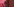 In rotes Licht getaucht, eine junge Frau wendet sich von einem Fenster ab.