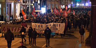 Ein Demonstrationszug wird von Transparenten mit der Aufschrift "Dem rechten Mob entgegentreten" und "Antifa" angeführt.