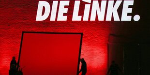 Der Schriftzug "die Linke" leuchtet weiß auf einer roten Wand