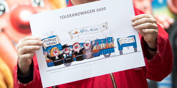 Jacques Tilly, Wagenbauer des Düsseldorfer Rosenmontagszuges, hält den Entwurf für den Toleranzwagen in den Händen.