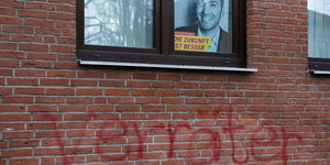 Auf einer Backsteinwand steht mit rotem Graffiti "Verräter" geschrieben, darüber im Fenster ein Wahlplakat von Konstantin Kuhle.