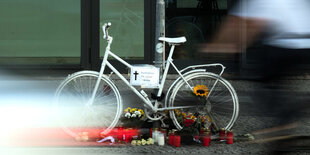 Weißes Fahrrad steht auf einem Bürgersteig