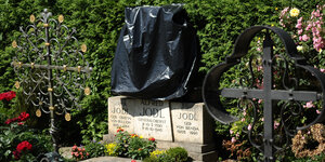 Das Grab der Familie Jodl. Ein Teil des Steins ist mit einem schwarzen Müllsack überstülpt worden.