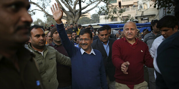 Arvind Kejriwal winkt vor einer Menschengruppe