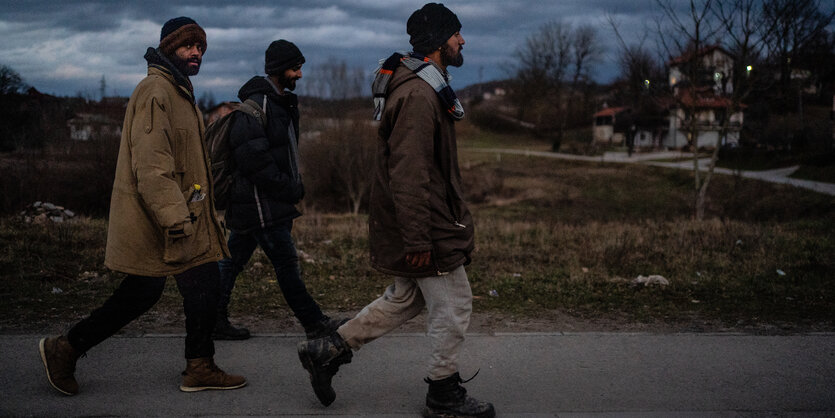 Drei Männer im Halbdunkel hintereinander