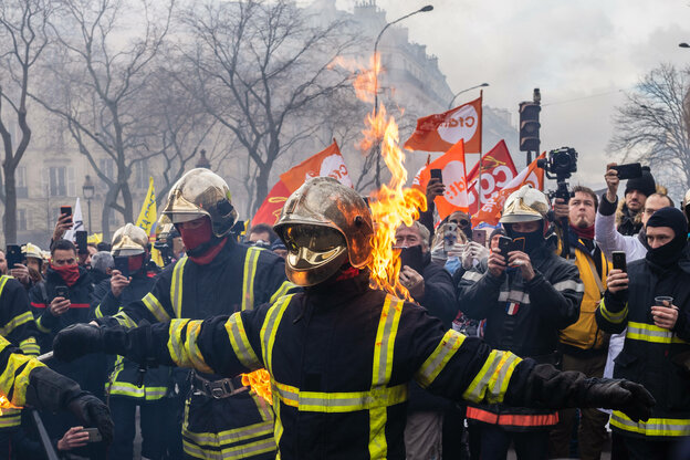 Ein Feuerwehrmann mit ausgebreiteten Armen steht in Flammen