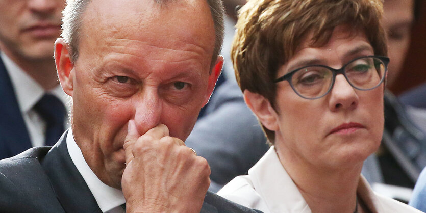 Friedrich Merz rümpft die Nase, neben ihm Kramp-Karrenbauer mit gelangweitem Blick