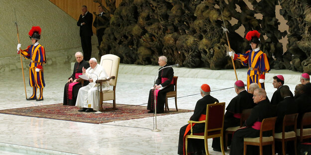 Papst Franziskus sitzt bei der wöchentlichen Audienz im Vatikan zwischen anderen Kirchenvertretern