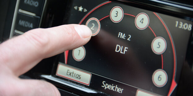 Autoradio-Anzeige: EIn Autofahrer stellt den Radiosender Deutschlandfunk ein Autoradio-Anzeige: EIn Autofahrer stellt den Radiosender Deutschlandfunk ein