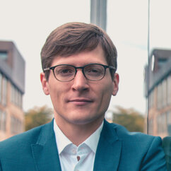 Portraitfoto Björn Asdecker, Mann mit Brille und Anzug