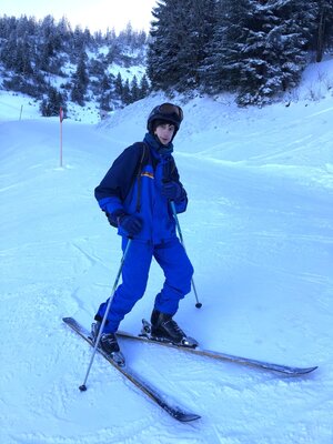Ein Mann auf Skiern im blauen Skianzug posiert auf Skipiste Ein Mann auf Skiern im blauen Skianzug posiert auf Skipiste