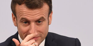 Frankreichs Präsident Macron greift sich an die Nase