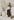 Eine alte schwarzweiße Fotografie, es liegt Schnee, Porträt eines Mannes, der mit Wintermantel und Mütze, Pinsel und Palette vor einer Leinwand steht, die an einer Birke lehnt.