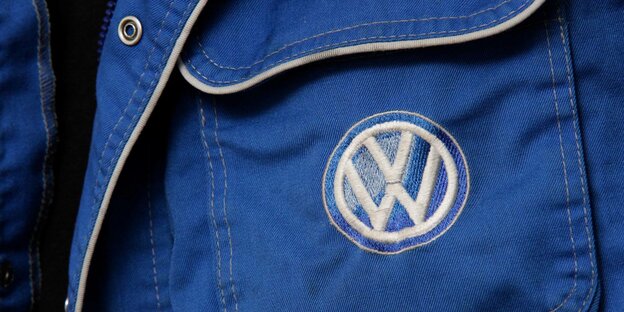 VW-Logo auf der Arbeitskleidung eines Mechatronikers.