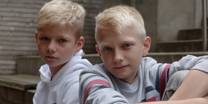 Zwei blonde Jungs, neun oder zehn Jahre alt, in Sportklamotten