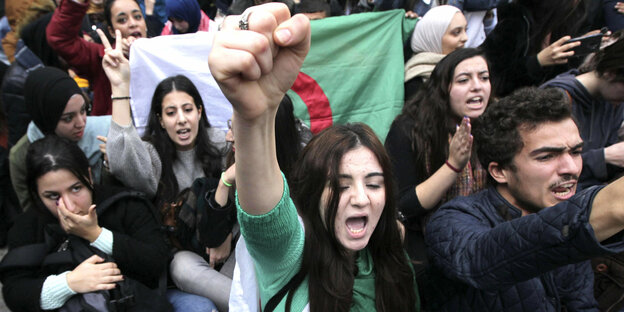 Eine Frau reckt die Faust bei Protesten in Algerien.