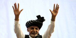 Der afghanische Präsident Aschraf Ghani winkt mit beiden Händen bei einer Veranstaltung.
