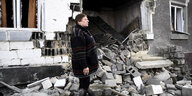 Eine Frau vor ihrem zersatörten Haus iun der Ukraine.