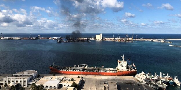 Rauchwolke über einem Schiff im Hafen von Tripolis