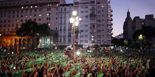 Demonstrantinnen halten grüne Flaggen hoch