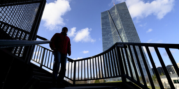 ein Mann geht eine Treppe entlang im Hintergrund die EZB