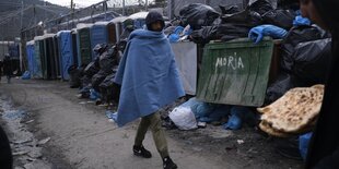 Ein Flüchtling läuft in eine Decke gehüllt im Flüchtlingscamp Moria auf Lesbos.