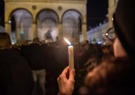 Eine Frau hält bei einer Mahnwache für die Opfer des rassistischen Anschlags eine Kerze hoch