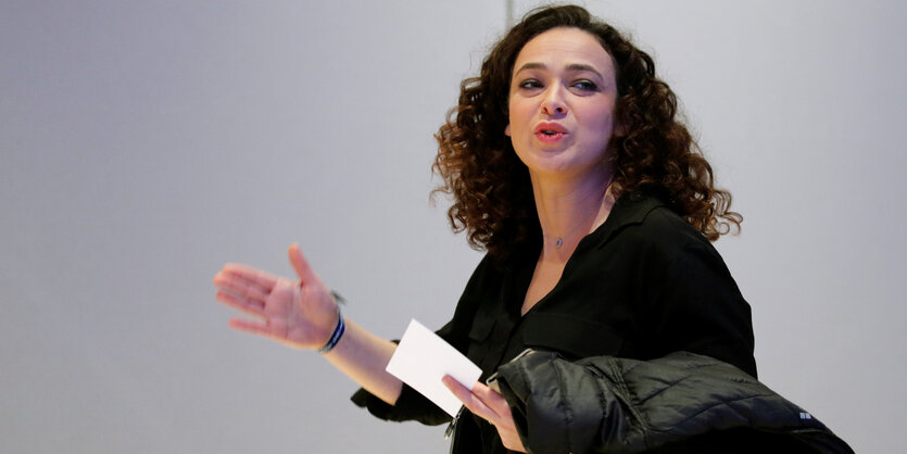 Delphine Horvilleur mit Jacke und einem Blatt Papier in der Hand im Laufen