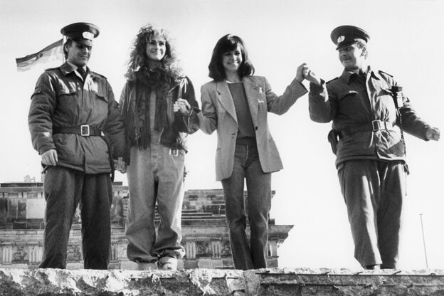Nach Maueroeffnung steht Julia Roberts mit zwei DDR-Grenzpolizisten auf der Berliner Mauer